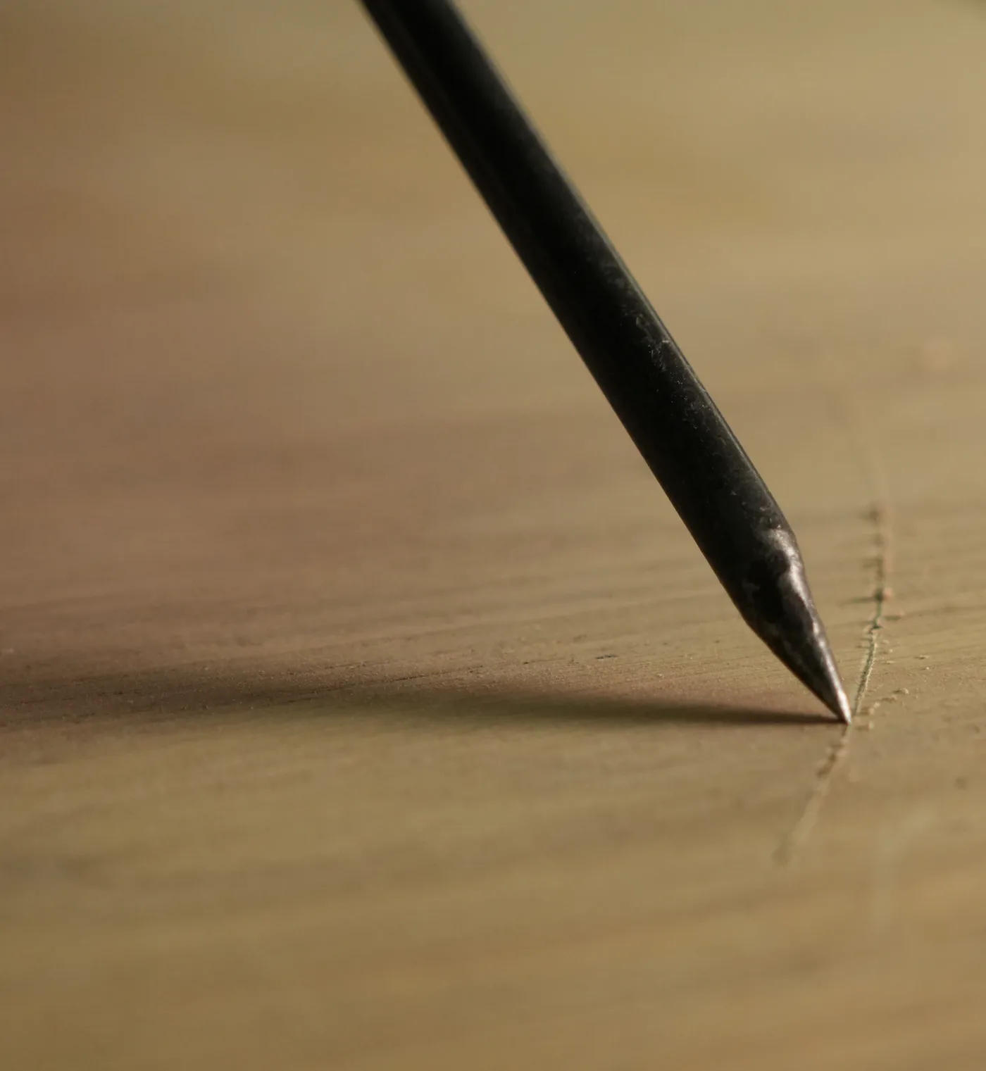Pointe d’un crayon qui trace une ligne sur du bois