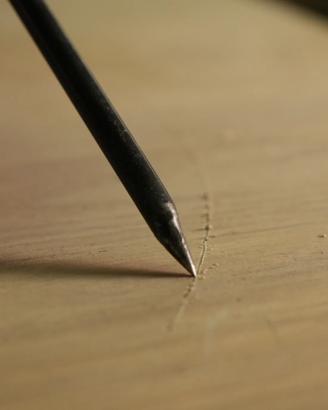 Pointe d’un crayon traçant une ligne sur du chêne
