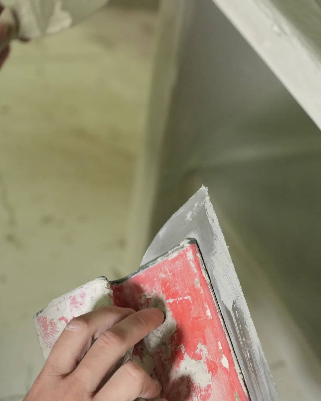 Artisane lissant à la spatule une étagère en béton ciré