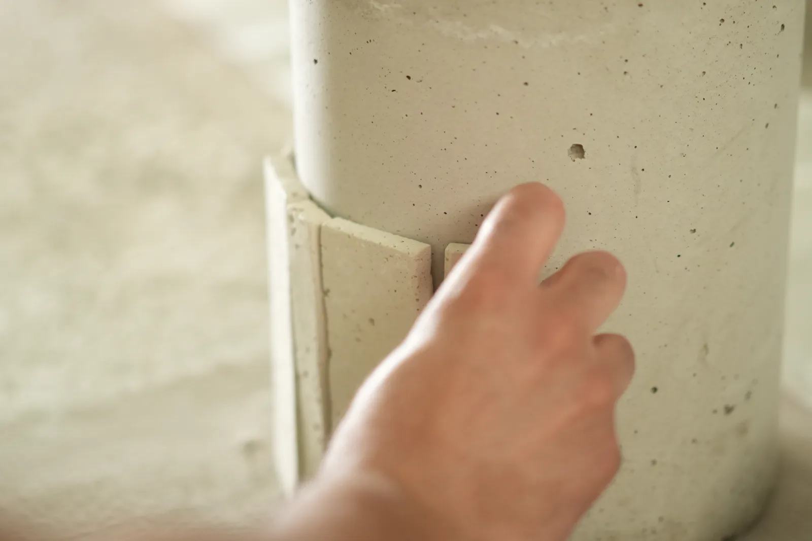 Main qui lisse l’angle d’une pièce en béton ciré