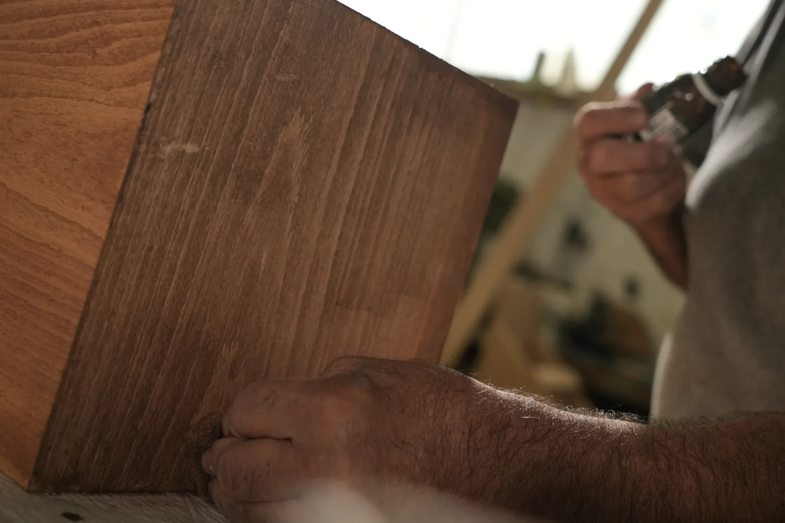 Main d’artisan sur une planche de noyer